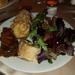 Buffet food. Some beef with gravy, stuffed chicken, baked potato, balsamic vegetable salad, and spring greens, asparagus