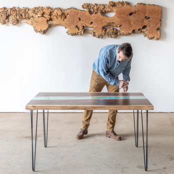 Kirkpatrick Designs - Fine Furniture Craftsman Kristopher Kirkpatrick cleans one of his signature resin and walnut dining tables prior to delivery. - Home Decor Near Me - San Leandro, California Kirkpatrick Designs - Fine Furniture Craftsman Kristopher Kirkpatrick cleans one of his signature resin and walnut dining tables prior to delivery. - Home Decor Near Me - San Leandro, California