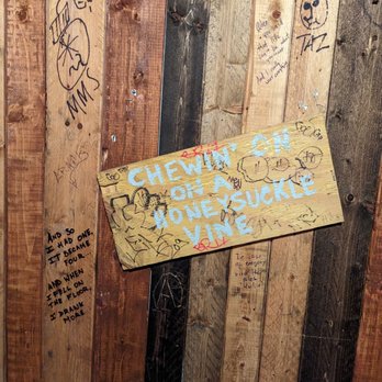 DUO Gastropub - a wooden sign with graffiti on it - Gastropubs Near Me - Queens, New York