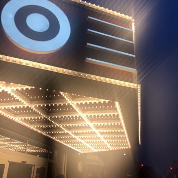 Target - Target marquee featuring yours truly TARGEÈ - Night scene featuring a marquee with a target logo illuminated by numerous light bulbs, with people standing below. - Furniture Stores Near Me - Brooklyn, New York