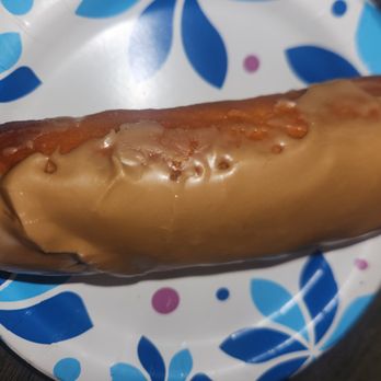 Mr Maple Donuts - Looks pornish - A donut with caramel glaze is placed on a blue and white patterned paper plate. - Donuts Near Me - Phoenix, Arizona