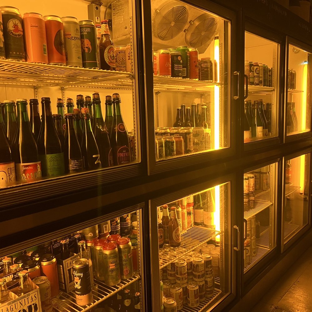 Covenhoven - a row of beer bottles in a refrigerator - Beer Bar Near Me - Brooklyn, New York