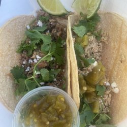 Olé Guacamole - One pork and one chicken taco with green chili sauce, topped with cilantro and queso fresco, no onions as requested.