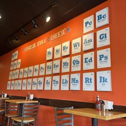a restaurant with orange walls and posters on the wall a restaurant with orange walls and posters on the wall