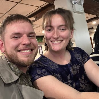 April's Pub & Grill - 2 Happy Customers! - A man and woman are smiling and taking a selfie together inside a building, with a ceiling and wall visible in the background. - American Near Me - Lynn, Massachusetts