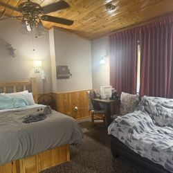 Vista Court Cabins & Lodge - Lodge room 11- love seat, table for 2, comfy queen bed, bench, mini fridge, microwave, tv, rocky and bullwinkle on the wall.
