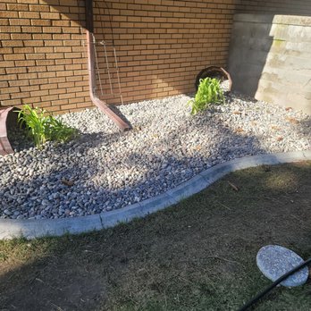 Underground Express - French drain in the center and lilies flowing out of the buckets. - Landscape Architects or Designers Near Me