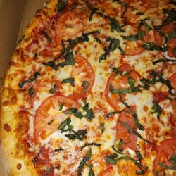 Brasa Bella Pizzeria - Large pizza with sliced tomatoes and basil.