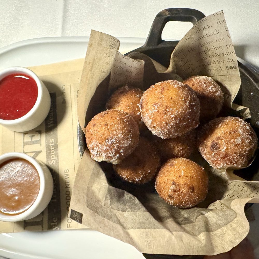 Sugared beignets, with salted Carmel and raspberry sauces. Sugared beignets, with salted Carmel and raspberry sauces.