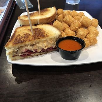 The Draft Sports Pub & Grill - Pastrami Reuben with an included side of tator tots and bonus buffalo sauce. - Sports Bars Near Me - Pleasanton, California The Draft Sports Pub & Grill - Pastrami Reuben with an included side of tator tots and bonus buffalo sauce. - Sports Bars Near Me - Pleasanton, California