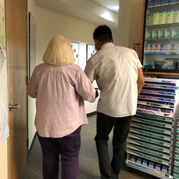 their summer intern, Thai (sp?), carefully escorting my 94 yr old mother to the exam room (she needs help walking).