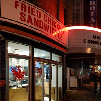 PG Clucks - Outside at night from on the sidewalk to the west with the theatre marquee also visible. May 2018 - Sandwiches Near Me - Toronto, Ontario