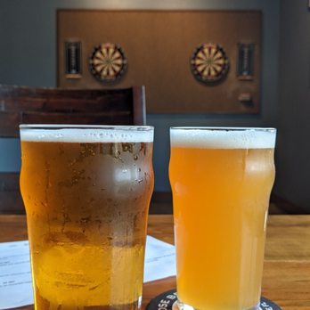 Dog Rose Brewing - Bobby Shorts on the left, Palace Pale Ale on the right.  They are not playing darts, regardless of the implication in the background - Breweries Near Me - St. Augustine, Florida