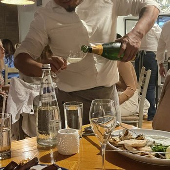 Calissa Hamptons - Our server bringing us a complimentary bottle of champagne - the owner knew our AirBNB host! - Mediterranean Near Me - Water Mill, New York