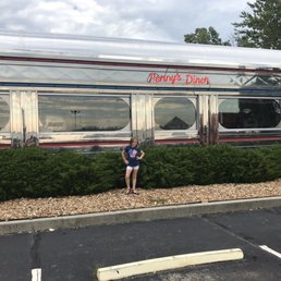 a woman sitting in front of a diner car