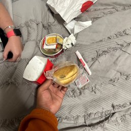 ows a person sitting on a bed eating a sandwich ows a person sitting on a bed eating a sandwich