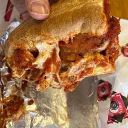 a hand holding a half eaten sandwich a hand holding a half eaten sandwich