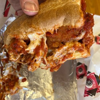 Brookside Pizza - a hand holding a half eaten sandwich - Pizza Near Me - Loudon, New Hampshire Brookside Pizza - a hand holding a half eaten sandwich - Pizza Near Me - Loudon, New Hampshire