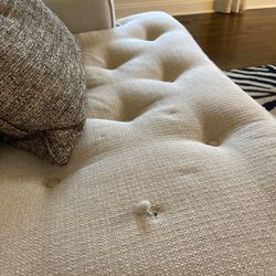 Atlanta Craftsman Interiors - Sofa cushion showing tuft needing repair.