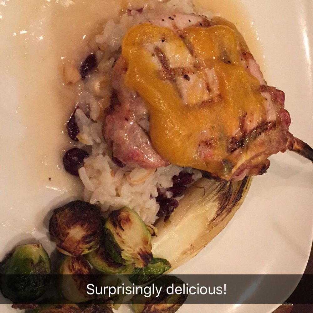 Pork chop with risotto, brussel sprouts, and endive.