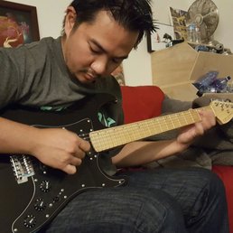 My boyfriend trying out the guitar I bought him.