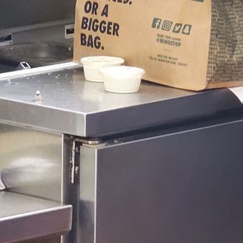 Wingstop - a bag of food sitting on top of a counter - Chicken Wings Near Me - Kilgore, Texas