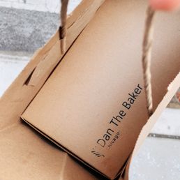 a hand holding a brown paper bag a hand holding a brown paper bag
