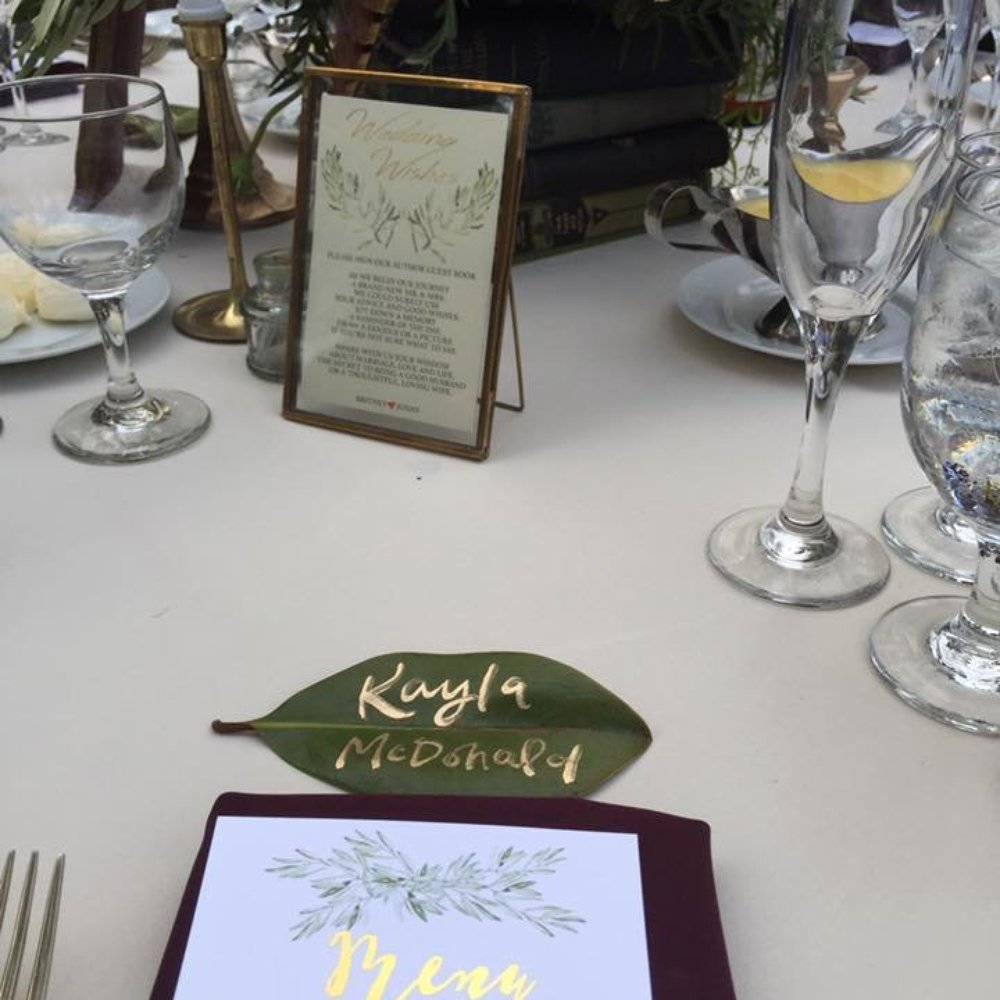 Olive Saint Lily - Gold calligraphy on real magnolia leaves - Graphic Design Near Me Olive Saint Lily - Gold calligraphy on real magnolia leaves - Graphic Design Near Me