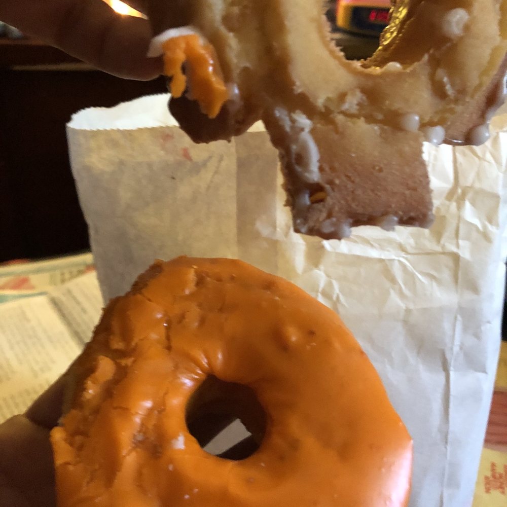 Golden West Donuts - a hand holding a glazed donut - Donuts Near Me - Norwalk, California Golden West Donuts - a hand holding a glazed donut - Donuts Near Me - Norwalk, California