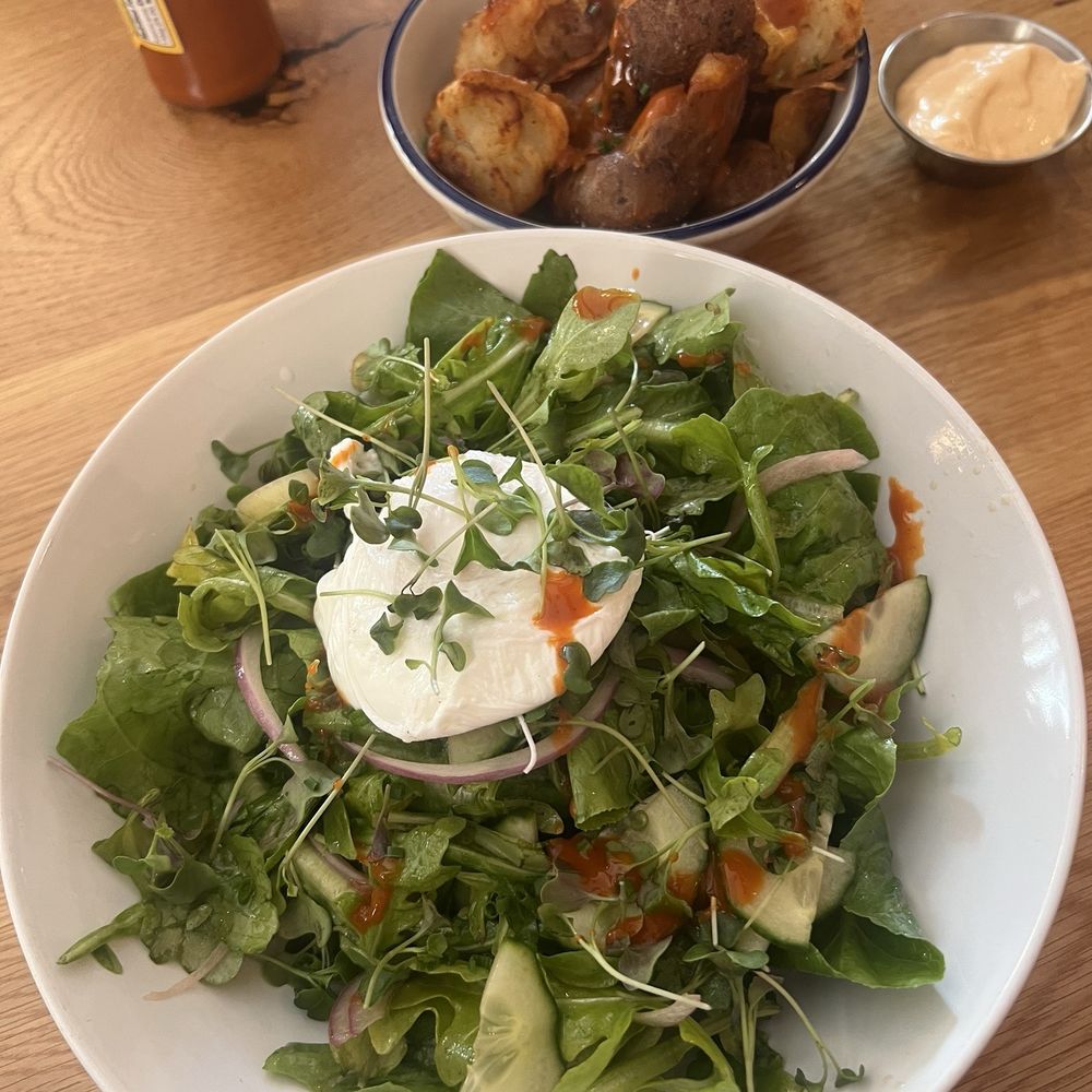 afternoon - Fresh herb salad with a poached egg on top and a side of home fries - New American Near Me - Gainesville, Florida