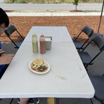 Taqueria Mi Barrio - Seating Area with Salsa Bottles - Food Trucks Near Me - Seattle, Washington