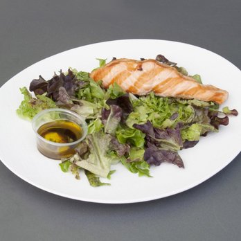 Markato - a white plate with a salad and salmon - Caterers Near Me - New York, New York Markato - a white plate with a salad and salmon - Caterers Near Me - New York, New York