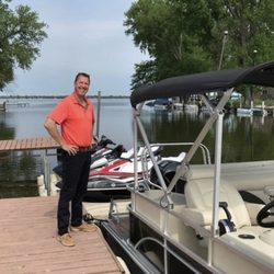 Lake Winnebago Boat & WaveRunner Rentals - Owner (Brad Lenz) next to the Yamaha WaveRunners and the Pontoon Boat with a 115 HP Mercury Outboard Motor.