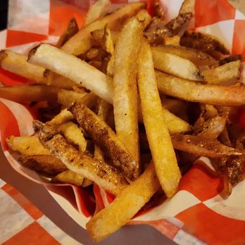 Layman Brewing - Side of hand cut fries - A basket filled with hand-cut French fries, some with crispy edges, served in a paper-lined basket at a dining establishment. - Brewpubs Near Me - West Allis, Wisconsin