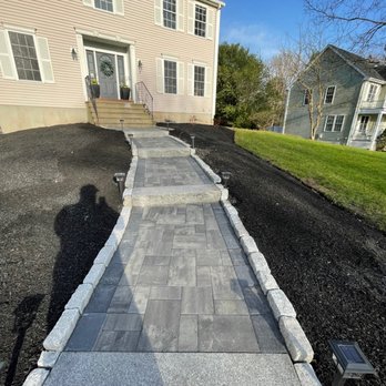 Leaves Landscaping - a driveway with a stone walkway leading to a house - Landscaping Near Me Leaves Landscaping - a driveway with a stone walkway leading to a house - Landscaping Near Me