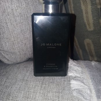 Jo Malone London - Jo Malone Cypress and Grapevine cologne intense bottle chilling by itself on the couch. - Perfume Near Me - Los Angeles, California