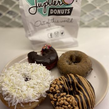 Jupiter Donuts - Banana coconut, red velvet with chocolate (with the bite taken out), blueberry, PB. - Donuts Near Me - Jupiter, Florida