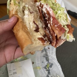 a person holding a sandwich with bacon and lettuce a person holding a sandwich with bacon and lettuce