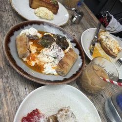Eggplant dish with cream focaccia and poached eggs, hash browns covered in cheese and peppers Peach glaze covered French toast