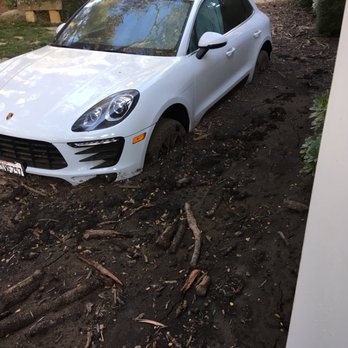 Oswald Construction - a white car stuck in the mud - General Contractors Near Me Oswald Construction - a white car stuck in the mud - General Contractors Near Me