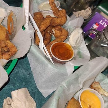 St James Irish Pub - Fried chicken tenders with various dipping sauces are served on a table with other fried foods and drinks. - Irish Near Me - Fall River, Massachusetts