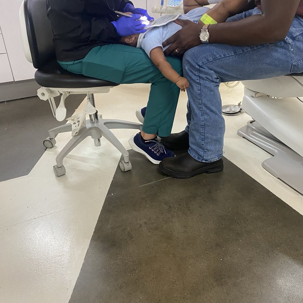 Greater Houston Pediatric Dentistry - My son being held by my lover and the dental assistant while she looks at his teeth - Pediatric Dentists Near Me - Katy, Texas Greater Houston Pediatric Dentistry - My son being held by my lover and the dental assistant while she looks at his teeth - Pediatric Dentists Near Me - Katy, Texas