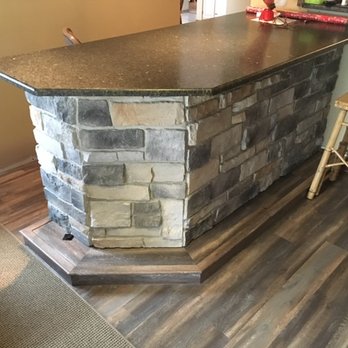 Perfected Flooring - a kitchen with a stone bar - Flooring Near Me Perfected Flooring - a kitchen with a stone bar - Flooring Near Me
