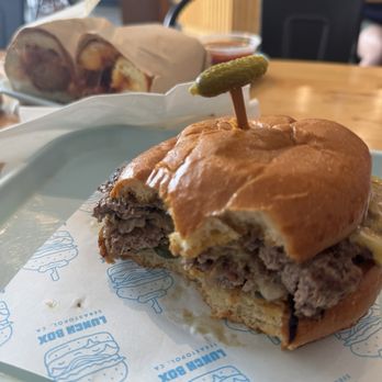 Lunch Box - Two big bites in before snapping a picture of their smash burger - Burgers Near Me - Sebastopol, California Lunch Box - Two big bites in before snapping a picture of their smash burger - Burgers Near Me - Sebastopol, California