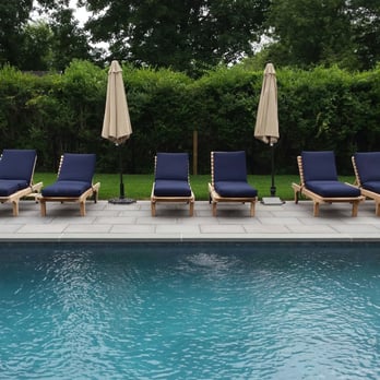 Sure Landscape & Design - a pool with lounge chairs and umbrellas - Landscaping Near Me - Little Silver, New Jersey Sure Landscape & Design - a pool with lounge chairs and umbrellas - Landscaping Near Me - Little Silver, New Jersey