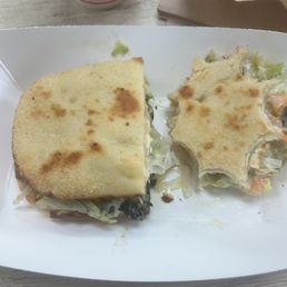 Half Sub & 1/2 fries - A sandwich with toasted bread and a side of potato salad are placed on a white tray, with a drink and paper bag in the background.