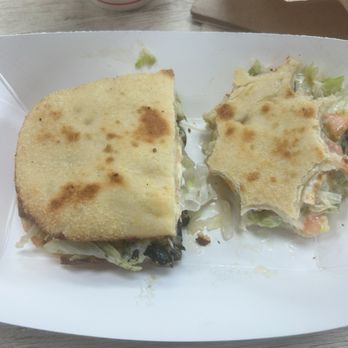 Original Geno's - Half Sub & 1/2 fries - A sandwich with toasted bread and a side of potato salad are placed on a white tray, with a drink and paper bag in the background. - Pizza Near Me - Tempe, Arizona
