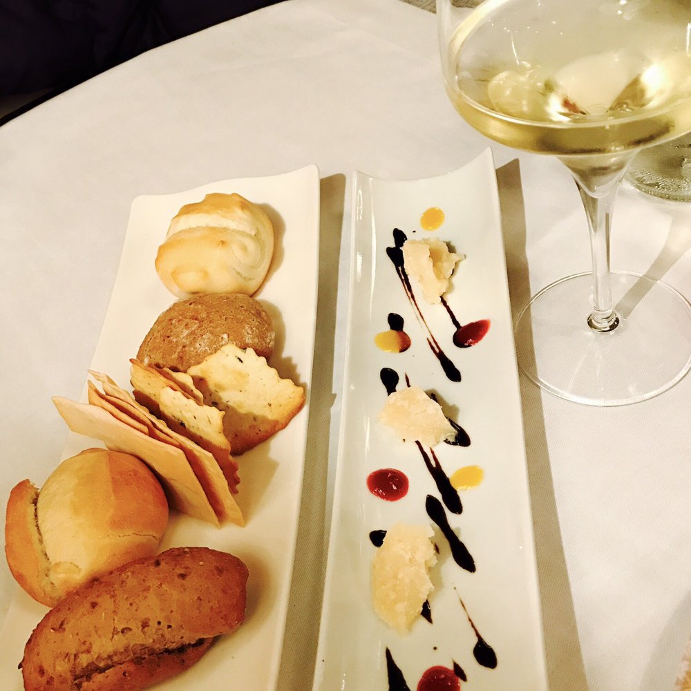 Complimentary warm bread and a plate of 'kitchen welcome Parmesan cheese'