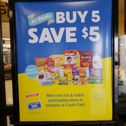 buy 5 save $ 5 sign in a grocery store