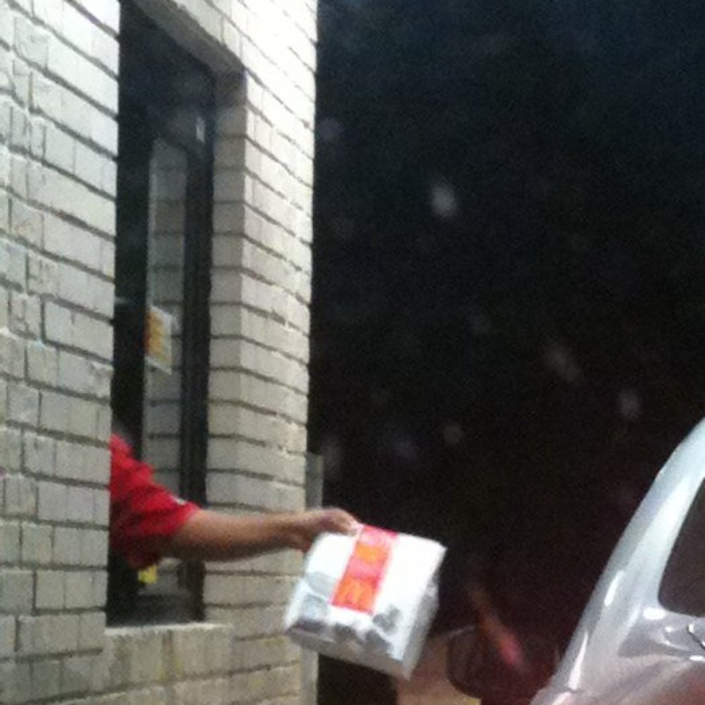 a man handing a package to a car a man handing a package to a car